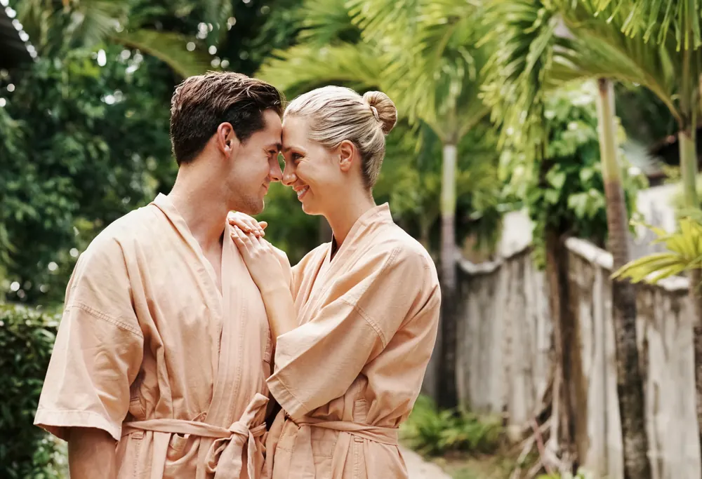 Couple in spa robes sharing a quiet romantic moment in a garden